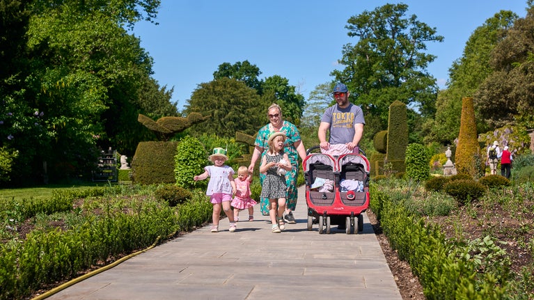A family of five walking down the newly improved path in the Long Garden at Cliveden, Buckinghamshire.